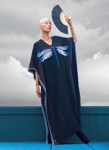 Black knit long poncho dress with blue dragonfly embroidery worn front