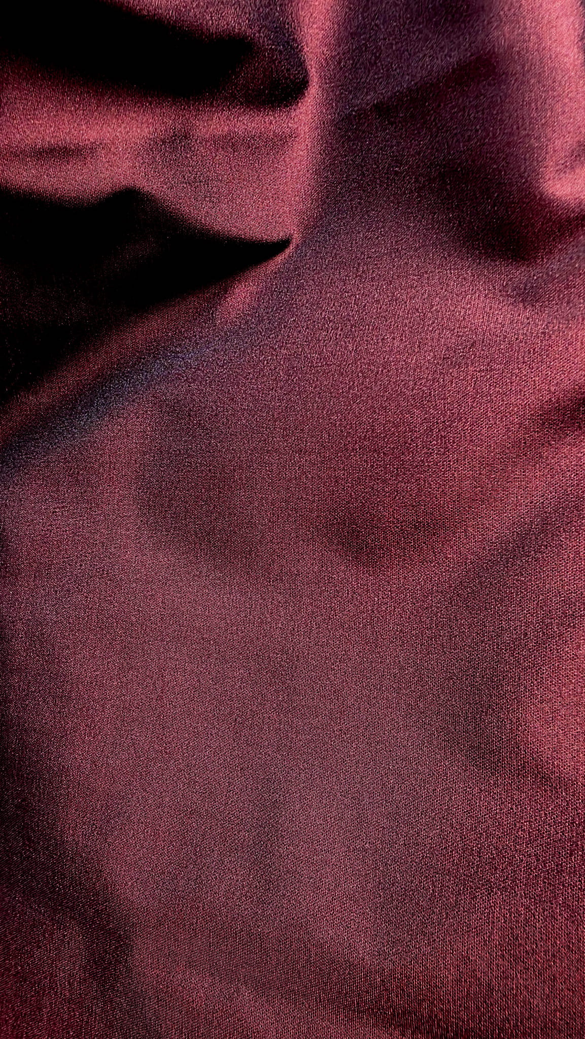 Close-up of the deep burgundy taffeta fabric showing its fine weave and elegant reflective sheen.