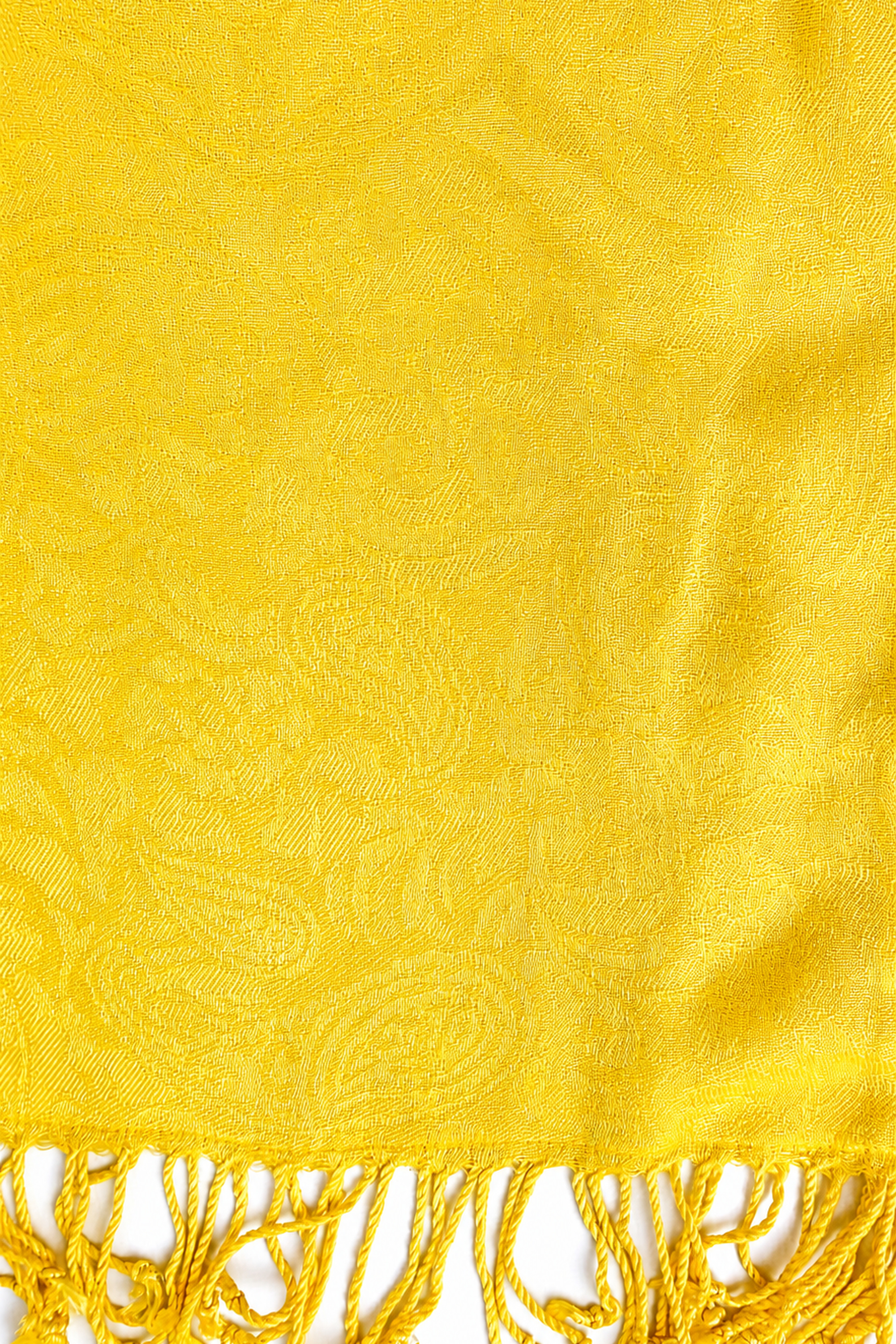 Close-up of the yellow jacquard fabric and hand-twisted fringe detailing of the turban.