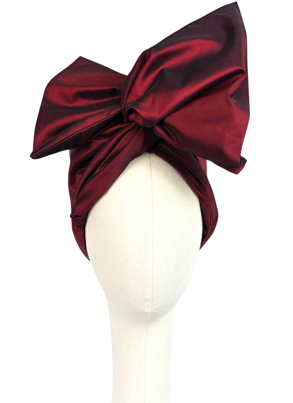 Front view of a women’s short burgundy taffeta Twist evening turban with an oversized sculptural bow.