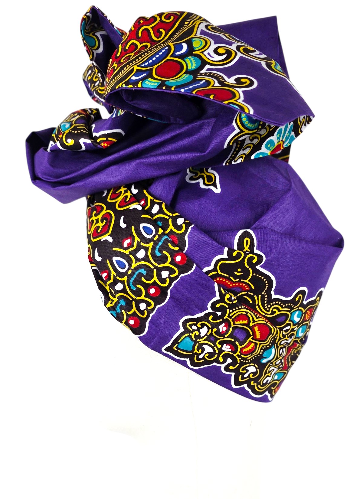 Three-quarter view of a purple turban showing large red, yellow and turquoise ornaments on stiffened African cotton fabric.